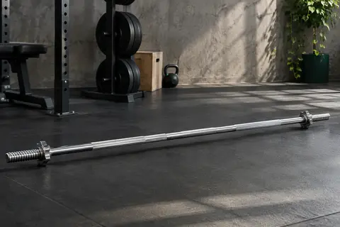 Barre de musculation chromée de 150 cm avec fermetures à vis, posée dans un home gym sobre