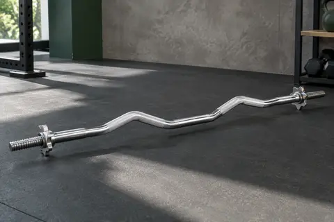 Barre curl EZ chromée avec poignées texturées et fermoirs étoile, posée dans un home gym sobre.