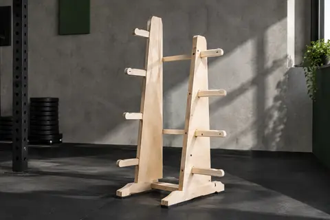 Support à disques MeansWood en bouleau installé dans un home gym sobre, sans poids rangés dessus