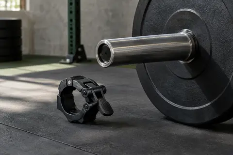 Collier de serrage noir en ABS posé près d’une barre olympique de 50 mm dans un home gym.